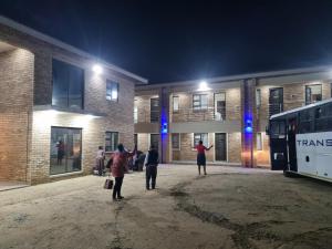 un grupo de personas de pie fuera de un edificio por la noche en Airport Airbnb en Richards Bay