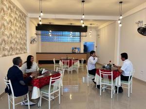 um grupo de pessoas sentadas em mesas em um restaurante em Hotel Presidencial em Chiclayo