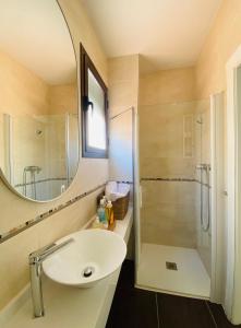 uma casa de banho com um lavatório e um chuveiro com um espelho. em La Fonda de la Calle Ancha em Guadix