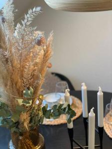 einen Tisch mit zwei Kerzen und eine Vase mit Pflanzen in der Unterkunft Skandinavisk City-lejlighed! in Odense