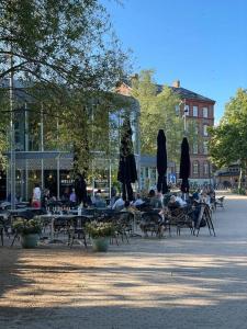 a group of people sitting at tables with umbrellas at Skandinavisk City-lejlighed! in Odense