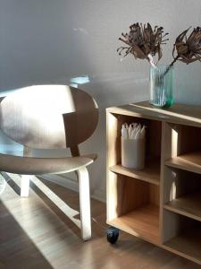 uma cadeira branca sentada ao lado de uma mesa e uma prateleira em Skandinavisk City-lejlighed! em Odense