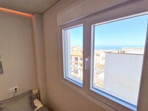 een kamer met een raam met uitzicht op de stad bij Emerald Apartment - Spacious Modern 2 Bedroom in Benalmádena