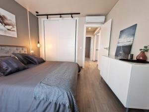 - une chambre avec un grand lit et des placards blancs dans l'établissement Emerald Apartment - Spacious Modern 2 Bedroom, à Benalmádena