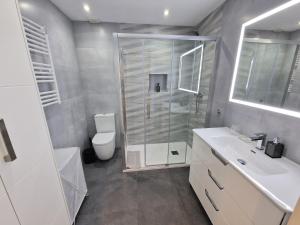 een badkamer met een douche, een toilet en een wastafel bij Emerald Apartment - Spacious Modern 2 Bedroom in Benalmádena