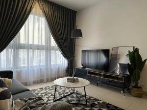 a living room with a couch and a tv and a table at Best for Family KLCC Pavillion Sunway Velocity MRT in Kuala Lumpur