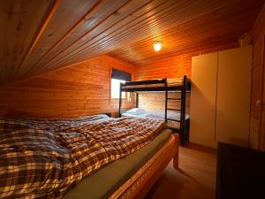 a bedroom with a bed in a wooden room at Nesset i Fiskfjord in Dragland