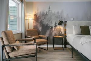 a bedroom with a bed and two chairs at Hickory Falls Inn in Chimney Rock