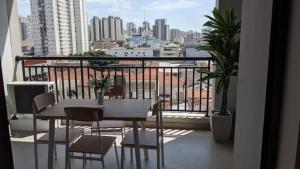 a table and chairs on a balcony with a view of a city at VN Bom Retiro in Sao Paulo