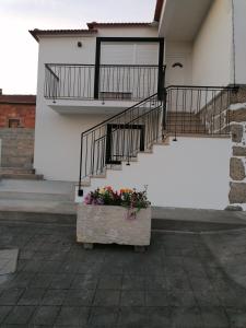 un sembrador lleno de flores delante de un edificio en Casa da Ilha Granjal Treixedo, 