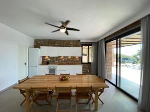 a kitchen with a wooden table and a ceiling fan at The Mavrolitharo Residence in Akti Salonikiou