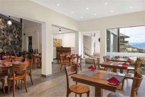 un ristorante con tavoli e sedie in legno e vista di Hotel Cassendra a Kandy