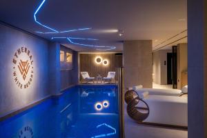 a hotel room with a swimming pool and a tub at Ethereal White Resort Hotel & Spa - Adults Only in Heraklio