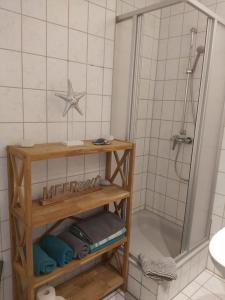 a bathroom with a shower and a shelf with towels at Wohnung Sonnenschein Wolgast in Wolgast