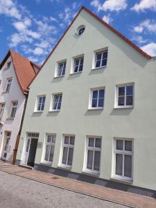 a white building with windows on a street at Wohnung Sonnenschein Wolgast in Wolgast