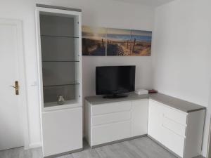 a living room with a tv on a white cabinet at Wohnung Sonnenschein Wolgast in Wolgast