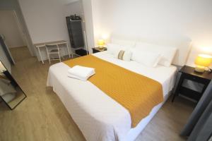 a bedroom with a large bed with a yellow and white blanket at Casa Ross in Valencia