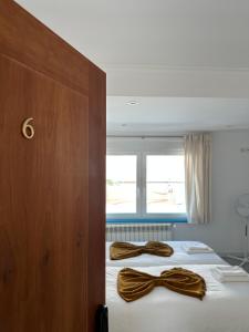 dwa brązowe krawaty na łóżku w pokoju w obiekcie Mega Ocean Magoito - Guest House - Sintra w mieście Sintra
