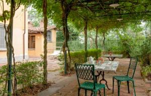 een patio met 2 stoelen en een tafel in de tuin bij Fattoria Uccelliera in Lorenzana