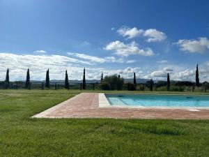 een zwembad in het midden van een grasveld bij Fattoria Uccelliera in Lorenzana