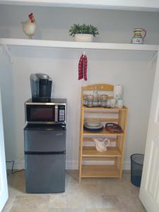 a kitchen with a microwave and a shelf with dishes at Million Dollar Lake View in Orlando