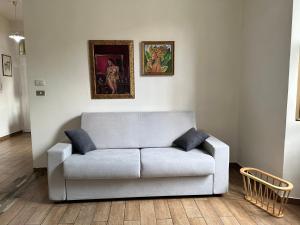 a couch in a living room with two pictures on the wall at COSENZA Savoia 16 in Cosenza