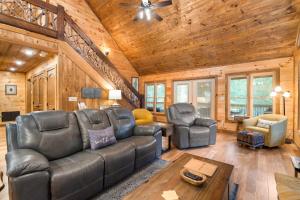 ein Wohnzimmer mit Ledermöbeln und Holzwänden in der Unterkunft Shalom in the Wood in Mineral Bluff