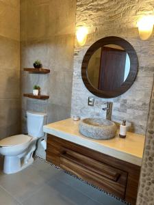 ein Badezimmer mit Waschbecken, Toilette und Spiegel in der Unterkunft Casa blanca playa saladita in Temalhuacán + 26 Fotos