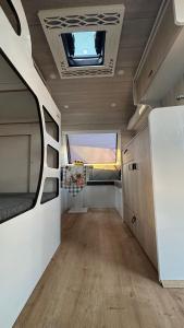 an interior view of an rv with a window and wood floors at Karavan tosbik in Lara