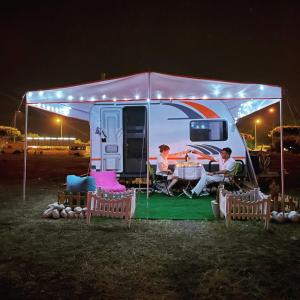 un grupo de personas sentadas dentro de una caravana por la noche en Karavan tosbik, en Lara