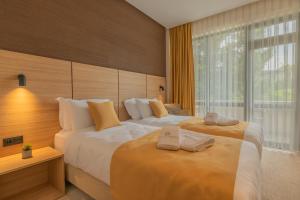 a hotel room with two beds with towels on them at Hotel Osetia Garden in Momchilgrad