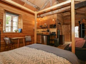 1 dormitorio con cama, mesa y cocina en Dog Crag Cabin, en Millom