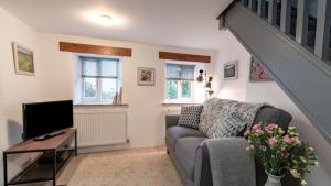 a living room with a couch and a tv at Little Hillside in Ashover
