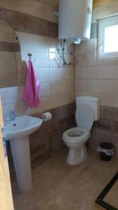 uma casa de banho com um WC branco e um lavatório. em Villa Te Ibra em Pec