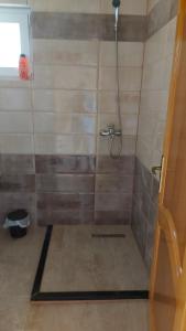 uma casa de banho com um chuveiro e uma porta de vidro em Villa Te Ibra em Pec
