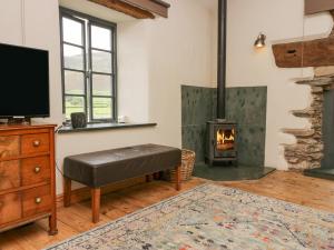 a living room with a tv and a fireplace at The Chapel in Millom