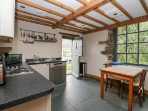 a kitchen with a wooden table and a counter top at The Chapel in Millom