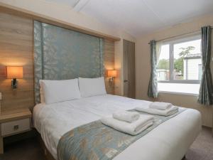um quarto com uma cama grande e toalhas em Mallard em Leominster