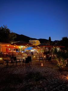 un grupo de mesas, sillas y sombrillas por la noche en Oscar Hotel Lefkada en Nydri