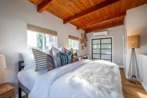 een slaapkamer met een groot wit bed met kussens bij Cozy Private Beach House - Steps from the beach in Oceanside