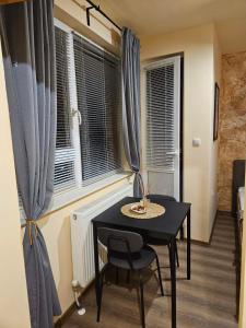Una mesa negra y una silla en una habitación con ventana en Дунав билдингс 3, en Pleven