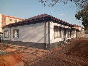 ein kleines weißes Gebäude mit einer großen Tür in der Unterkunft Las Palmas Day & Night Guest House in Pretoria