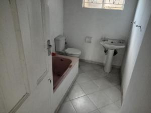 ein Badezimmer mit einer Badewanne, einem WC und einem Waschbecken in der Unterkunft Las Palmas Day & Night Guest House in Pretoria