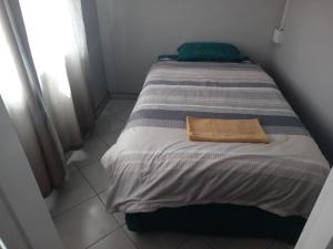a bed with a towel on it in a room at Las Palmas Day & Night Guest House in Pretoria