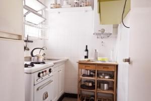 Apartment Dr.Romulo Naon في بوينس آيرس: مطبخ مع موقد ابيض وثلاجة بيضاء