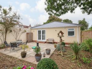 eine Terrasse mit einem Tisch und Stühlen im Hinterhof in der Unterkunft Gabby's Garden Cottage in Hull