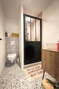 a bathroom with a toilet and a glass shower at Le petit Arth&M Clermont Ferrand in Clermont-Ferrand