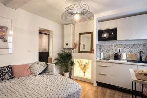 a living room with a bed and a kitchen at Le petit Arth&M Clermont Ferrand in Clermont-Ferrand