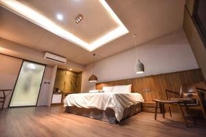 um quarto com uma cama, uma mesa e cadeiras em Two Couples Leisure Art Motel em Tainan