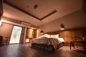 台南的住宿－貳侶休閒藝術旅館，一间卧室配有一张床、一张桌子和一个窗户。